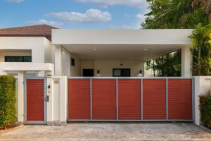una puerta de garaje roja frente a una casa en Thai-Themed 3br Boutique Villa by Intira Villas en Rawai Beach