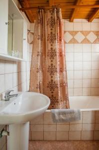 baño con lavabo y cortina de ducha en Villa Thymarmi Paradise, en Gouves