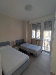 a bedroom with two beds and two windows at Residenza al Lago in Germignaga