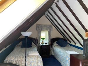 a attic bedroom with two beds and a window at Loch Arklet House in Stirling