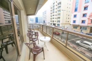 a balcony with a table and chairs and a view of a city at SARJAK'S HOSTEL MANKHOOL in Dubai