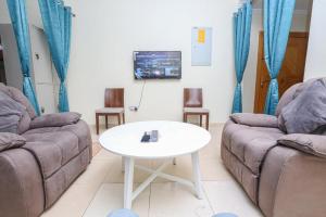 SARJAK'S HOSTEL MANKHOOL في دبي: غرفة معيشة مع كنبتين وطاولة
