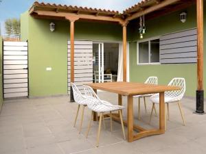 Une table et des chaises en bois sont disponibles sur la terrasse. dans l'établissement Villa La Orotava, à San Miguel de Abona