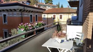 a balcony with a table and flowers on a building at Le Betulle in Verona