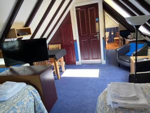 a attic room with a bed and a living room at Loch Arklet House in Stirling