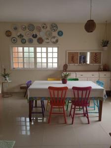 a kitchen with a table and chairs and plates on the wall at CASA LUZ PRAIA & PAZ in São Sebastião