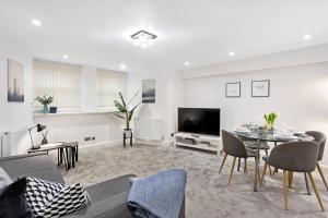 sala de estar con mesa y TV en Fountains Executive Apartment - Harrogate Stays, en Harrogate