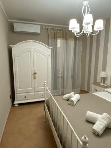a white bedroom with a crib and a chandelier at Sweet home in Mandra Capreria
