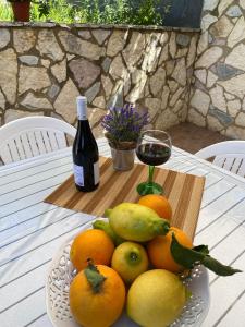 a plate of fruit on a table with a bottle of wine at Sweet home in Mandra Capreria