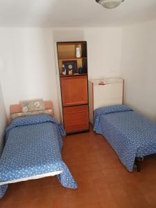 ラヴェーノ・モンベッロにあるAppartamento Piccolo Porto di Cerroのベッド2台とドレッサーが備わる客室です。
