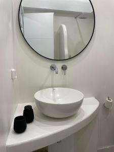 a bathroom with a white sink and a mirror at Konstantza's Elegant Apartment in Naxos Chora