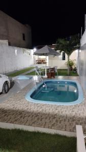 una pequeña piscina en un patio por la noche en CASA DE TEMPORADA RECANTO FELIz 2 en Aracaju