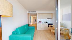 a living room with a blue couch and a kitchen at Sea Nest in Portimão