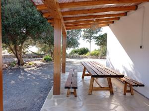 drewniany stół piknikowy i ławka na patio w obiekcie Sa Vinya Casa de Campo w mieście Es Cubells