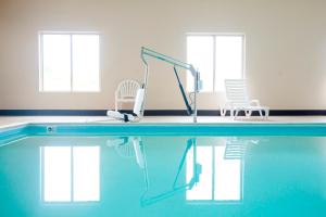 a swimming pool with two chairs and a swimming pool at Red Roof Inn London I-75 in London