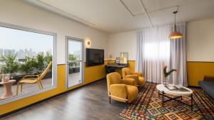 特拉维夫PLAY Seaport Suite Hotel TLV的带沙发、椅子和桌子的客厅