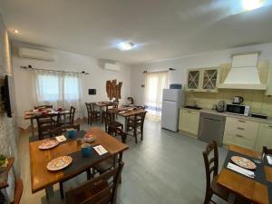 une cuisine et une salle à manger avec des tables et des chaises dans l'établissement Sa Domo De Rosa, à Budoni