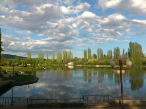 a large lake with trees and clouds in the sky at Gabko Apartment - great location and a comfortable stay! in Stara Zagora