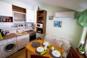 uma pequena cozinha com uma mesa e um lavatório em Gabko Apartment - great location and a comfortable stay! em Stara Zagora