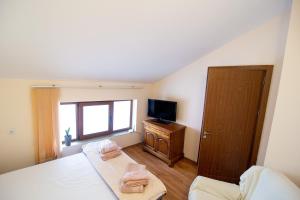 a small bedroom with a bed and a television at Gabko Apartment - great location and a comfortable stay! in Stara Zagora