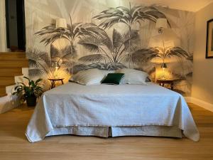 a bedroom with a bed with a wall with plants at Burlamacchi Villas in Bagni di Lucca