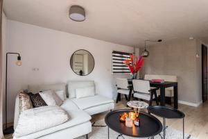 ein Wohnzimmer mit einem weißen Sofa und einem Tisch in der Unterkunft Boutique Chalet Veluwe in Putten