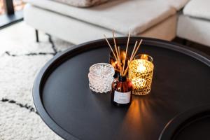een zwarte tafel met een fles en kaarsen erop bij Boutique Chalet Veluwe in Putten