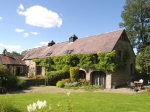 una vecchia casa in pietra con sopra edera di Ty Cefn Tregib B&B a Llandeilo