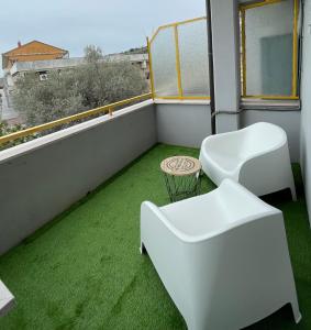 balkon z zieloną trawą i białymi meblami w obiekcie Dimora Dalmazia w mieście Vasto