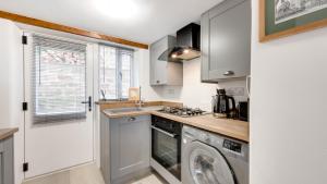 a kitchen with a washing machine and a washer at Little Hillside in Ashover