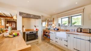 a kitchen with white cabinets and a counter top at Railway Cottage 