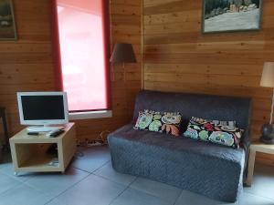 a room with a couch and a computer on a table at La Prairie in Noyers-sur-Jabron