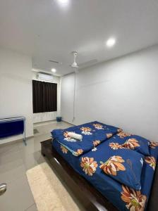 a bedroom with a bed with a blue blanket at D'has Homestay, Tmn Seri Impian, Kluang, Johor in Layang Village