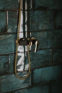 a shower with a hose hanging on a brick wall at Halacs Homes- Boutique cabins, Boutique Cabin in Balatonalmádi