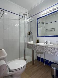 a bathroom with a toilet and a sink and a shower at Hotel Ramis in Ondara