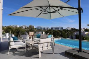 taras ze stołem, krzesłami i parasolem w obiekcie Deluxe VILLA LAVANDA Las Colinas DEHESA DE CAMPOAMOR with HEATED POOL w mieście Campoamor