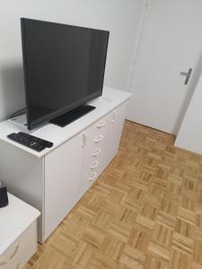 un soggiorno con TV su una scrivania bianca di Apartma MB center a Maribor
