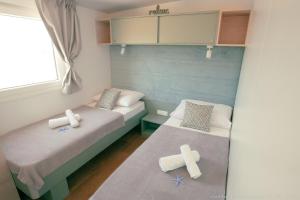 two beds in a small room with crosses on the floor at Mobilheim Maja in Nin