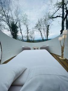 a bedroom with a large white bed and trees at Fun'ambulle in Féneyrols