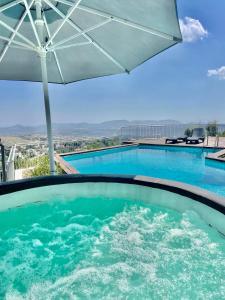 una piscina con sombrilla y una piscina en Reunion in Greece Villa, en Drafí