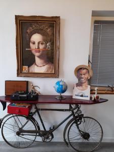 een fiets geparkeerd in een kamer met een portret van een vrouw bij l atelier d alex in La Baule