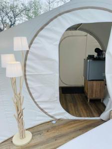 Fun'ambulle في Féneyrols: خيمة بيضاء مع مصباح في الغرفة