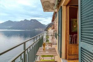 una mesa en un balcón con vistas al agua en Paolo's Home - overlooking the Lake en Colonno