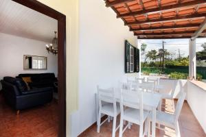 una sala da pranzo con sedie bianche e tavolo di Uma Quinta na praia, vista mar a 2 passos de Lisbo a Costa da Caparica