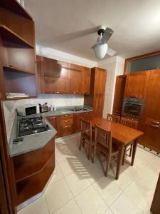 a kitchen with wooden cabinets and a wooden table with chairs at Apartment Donatello in Mestre