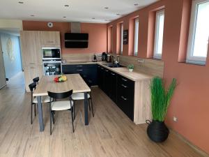 a kitchen with a table and chairs in a room at Le Relais de la Fontaine & Jacuzzi in Montcornet