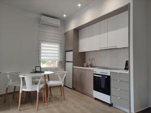 a kitchen with white cabinets and a table and chairs at Partcon Studio in Private Property B in Neoi Epivates