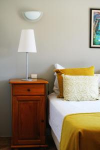 een slaapkamer met een bed en een lamp op een nachtkastje bij Vila Limão in Boliqueime