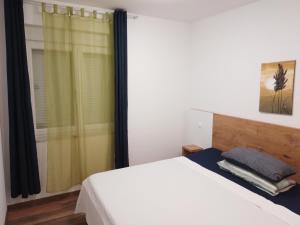 ein Schlafzimmer mit einem weißen Bett und einem Fenster in der Unterkunft Vila Cissa in Novalja