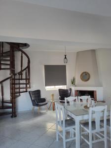 sala de estar con mesa blanca y sillas en Villa Michalis en Katalagárion